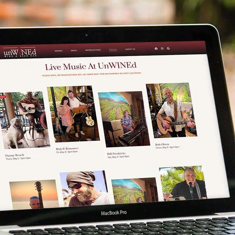 Close-up of laptop displaying the live music schedule on the new UnWINEd Wine+Beer Bar website
